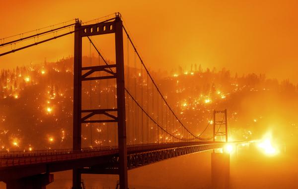 Καλιφόρνια, ΗΠΑ, 9 Σεπτεμβρίου 2020: Η γέφυρα Bidwell Bar με φόντο πυρκαγιά που κατακαίει δάσος.