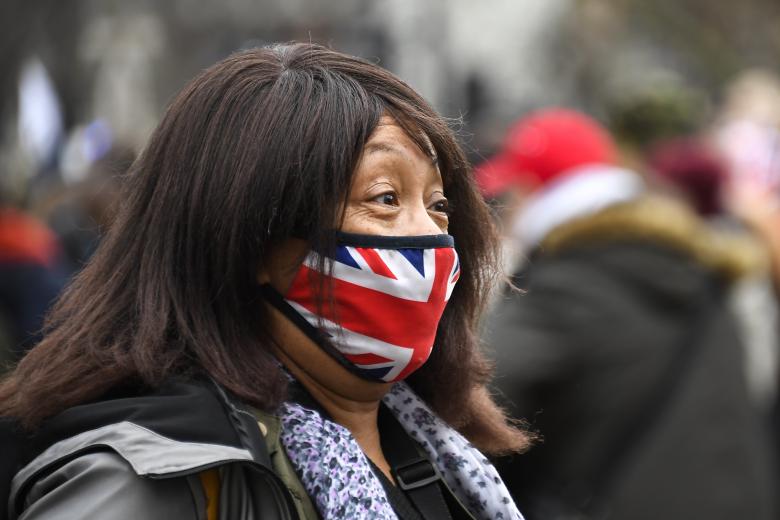 Βρετανή με μάσκα τη βρετανική σημαία έξω από το Κοινοβούλιο στο Λονδίνο / Πηγή: AP Images